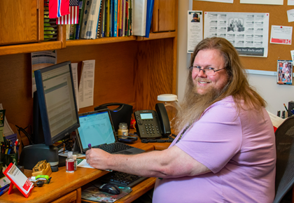 Man with long beard sitting at desk